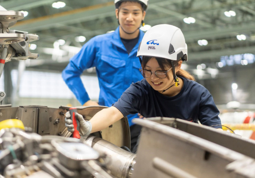 写真：先輩社員が若手社員の作業を見守る様子